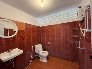 a bathroom with a toilet and a sink and a mirror at Honey Zen Zone in Ko Mak