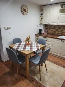 a kitchen with a table with chairs and a clock on the wall at Cottage House in Pača