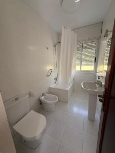a white bathroom with a toilet and a sink at Pensión O Regato in Redondela +51 photos
