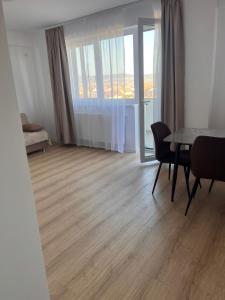 a living room with a table and chairs and a window at Confort Suite in Alba Iulia +2 photos
