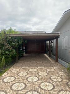 a house with a tile patio in front of a building at Residência Rosalaura in Balneário Gaivotas