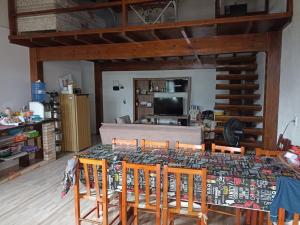 a dining room with a table with chairs and a couch at Residência Rosalaura in Balneário Gaivotas