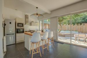 a kitchen with white appliances and a table and chairs at Maison des Abatilles- Bassin Arcachon in Arcachon