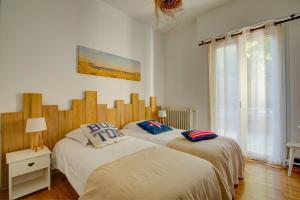 two twin beds in a bedroom with a window at Maison des Abatilles- Bassin Arcachon in Arcachon