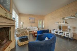 a living room with blue chairs and a fireplace at Maison des Abatilles- Bassin Arcachon in Arcachon
