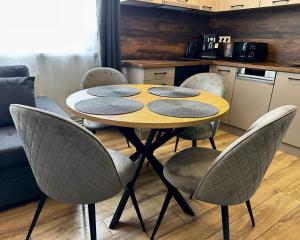 a table with four chairs in a kitchen at DB Guest House 2 in Târgu Secuiesc