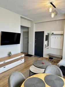 a living room with two tables and a flat screen tv at DB Guest House 2 in Târgu Secuiesc