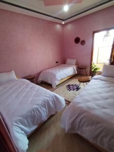 a bedroom with two beds and a window at Nomad Surf Morocco in Imsouane