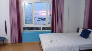 a bedroom with a bed and a large window at Thanh Tran Guesthouse Lý Sơn in Ly Son