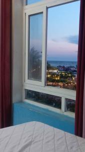 a bedroom window with a view of a city at Thanh Tran Guesthouse Lý Sơn in Ly Son