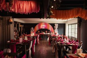 a dining room with long tables with red tablecloths at Brigg White Hart - Total Pub Takeover in Brigg