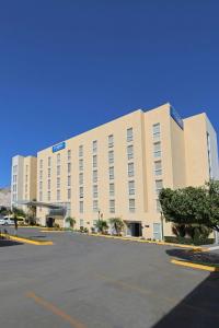 a large building with a parking lot in front of it at City Express by Marriott Tijuana Insurgentes in Tijuana