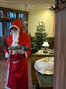 una persona vestita da Babbo Natale che impugna un'arma di Hotel BB Bahnhof Bertsdorf a Olbersdorf Altre 199 foto