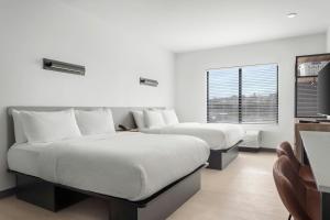 a bedroom with two beds and a desk and a window at StudioRes by Marriott Oak Ridge in Oak Ridge