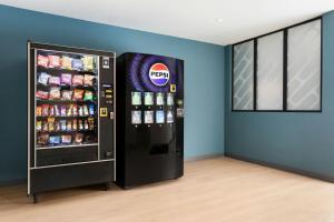 a soda refrigerator in a room next to a wall at StudioRes by Marriott Oak Ridge in Oak Ridge