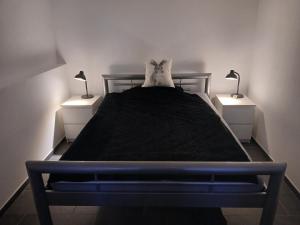 a bedroom with a black bed with two night stands at FeWo Eriswil by R&B in Eriswil