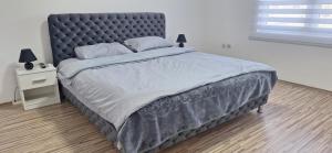 a bedroom with a large bed with a black headboard at Vila Marjanovic PN in Paraćin +7 photos