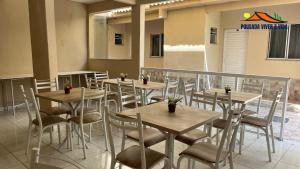 a row of tables and chairs in a restaurant at Ninho do Vale - Centro Conservatória in Conservatória