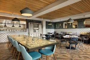 a restaurant with a large table and chairs at The Casso, Raleigh, a Tribute Portfolio Hotel in Raleigh