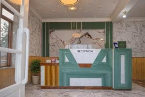 a reception area with a green and white sign in a room at Gulmarg Gul Sitara Resorts in Gulmarg