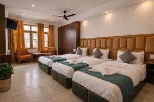 a hotel room with two beds and a desk at Gulmarg Gul Sitara Resorts in Gulmarg +5 photos
