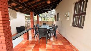 a porch with a table and chairs on a patio at Coastal Hideout Family Cottages Malpe Beach in Malpe
