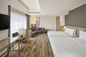 a hotel room with two beds and a couch at Yong Le Lukang, a Tribute Portfolio Hotel in Lukang +25 photos
