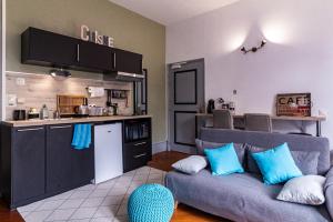 a living room with a couch and a kitchen at La Villa in Rouen