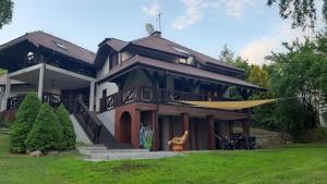 a large house with a surfboard in the yard at Siedlisko Ostropest Karbowskie 9a in Karbowskie