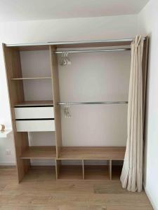 a closet with wooden shelves and a curtain at Joli T2 proche parc expo in Mulhouse