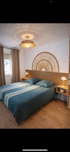 a bedroom with a large bed with a wooden headboard at Joli T2 proche parc expo in Mulhouse