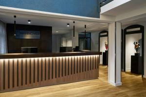 a hotel lobby with a reception desk and a pharmacy at Four Points Flex by Sheraton Hannover in Hannover