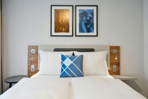 a bedroom with a bed with two pictures on the wall at Four Points Flex by Sheraton Hannover in Hannover +34 photos
