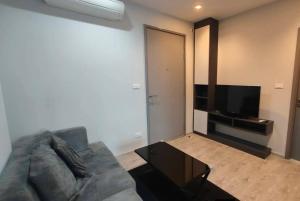 a living room with a couch and a flat screen tv at The Base Central Pattaya in Pattaya