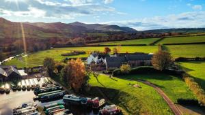 an aerial view of a house and a river with boats at Dragonfly Cottage, Canal location in Brecon