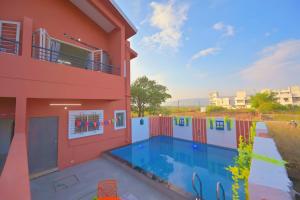 a house with a swimming pool next to a building at ll EMPYREAN STAY ll THE LOVE SHAKE ll 2BHK ll AC ll PRIVATE POOL ll BACHELORS FRIENDLY ll in Malavli +34 photos
