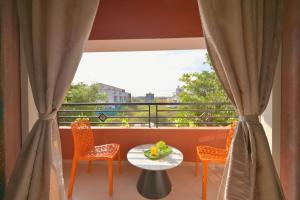 a balcony with a table and chairs and a window at ll EMPYREAN STAY ll THE LOVE SHAKE ll 2BHK ll AC ll PRIVATE POOL ll BACHELORS FRIENDLY ll in Malavli