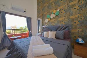 a bedroom with a bed with a blue bedspread and a wall at ll EMPYREAN STAY ll THE LOVE SHAKE ll 2BHK ll AC ll PRIVATE POOL ll BACHELORS FRIENDLY ll in Malavli