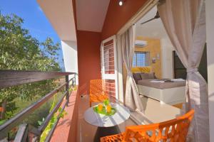 a balcony with a table and chairs and a bed at ll EMPYREAN STAY ll THE LOVE SHAKE ll 2BHK ll AC ll PRIVATE POOL ll BACHELORS FRIENDLY ll in Malavli