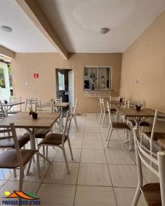 a dining room with wooden tables and chairs at Ninho do Vale - Centro Conservatória in Conservatória