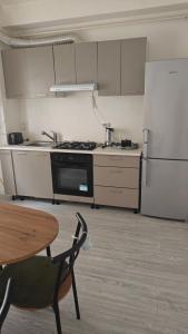 a kitchen with a stove and a table and a refrigerator at Ultracentral Biblioteca in Caracal