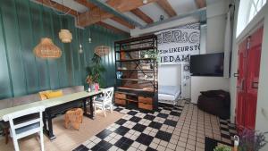a room with a table and chairs and a tv at Het Pakhuis Schiedam in Schiedam