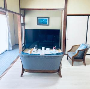 a bathtub in the middle of a room with two chairs at 福のや in Unnan