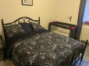 a bedroom with a bed with a black and white comforter at Gîte au Petit Café in Châteauvillain