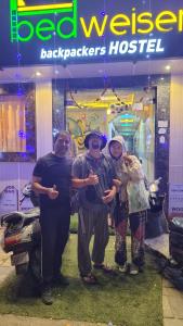 a group of three people standing in front of a store at Bedweiser Backpackers Hostel in Agra