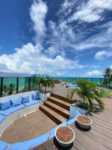 a deck with a couch and a view of the ocean at Prive Beira Mar Tamandare in Tamandaré