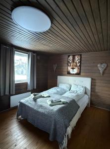 a bedroom with a bed with a tiger picture on the wall at Holiday Suite in Bugøynes
