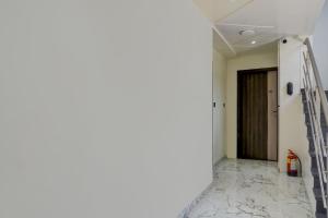 a corridor with a staircase in a room with white walls at Townhouse Poona Royal in Pune