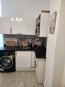 a kitchen with a sink and a washing machine at Aqua Palms Resort D101 in El Gouna