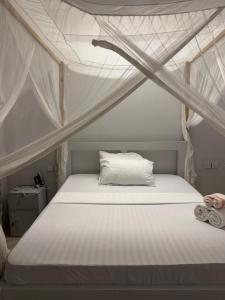 ein weißes Bett mit Baldachin in einem Zimmer in der Unterkunft Dindini in Kilindoni